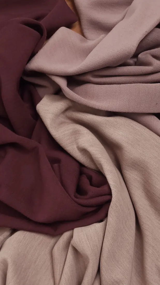 Το μαλακό, τσαλακωμένο ύφασμα Ζέρσεϋ ολόμαλλο σε αποχρώσεις του καστανού και του ανοιχτού μπεζ, σε στρώσεις και ντραπέ, δημιουργεί μια υφή και μια ζεστή εμφάνιση. Υφάσματα Ιχτιάρογλου